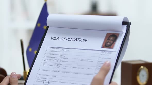 Manager Looking Through European Union Visa Application, Marking Approved