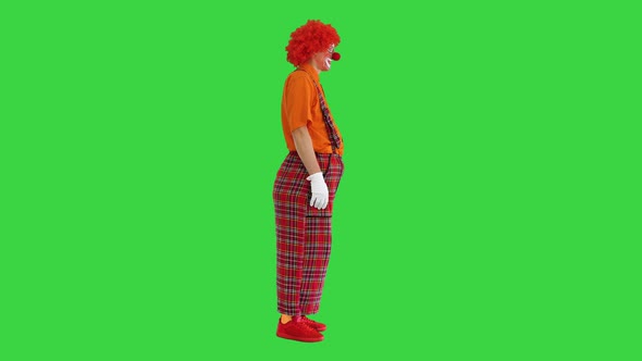 Funny Clown in Red Pants Standing and Talking To Someone on a Green Screen Chroma Key