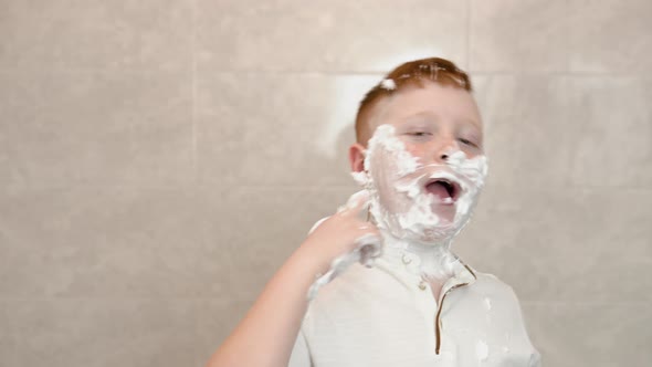 Funny Boy in the Bath Smears His Face with Shaving Cream Shows a Sign of Consent with His Thumb Up