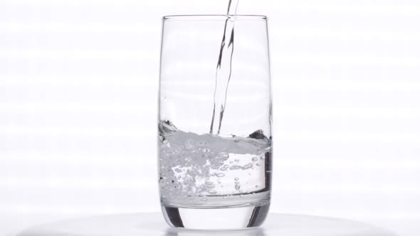 Pouring Clean Fresh Water in Transparent Glass Slow Motion Isolated