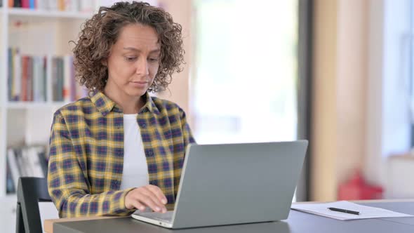 Excited Mixed Race Woman Celebrating Success on Laptop 