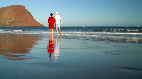 Couple in Love Carefree Walking To the Water on the Beach