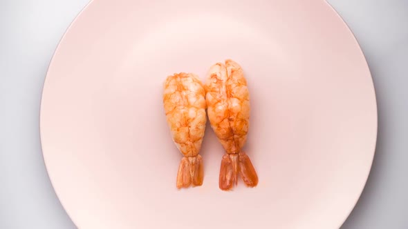 Top View of Two Shrimp Nigiri Sushi on the Spinning Pink Plate.