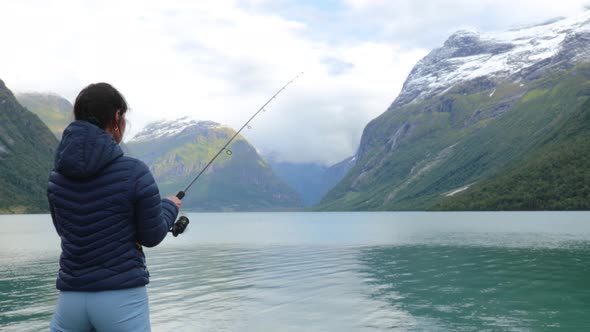 Woman Fishing on Fishing Rod Spinning in Norway