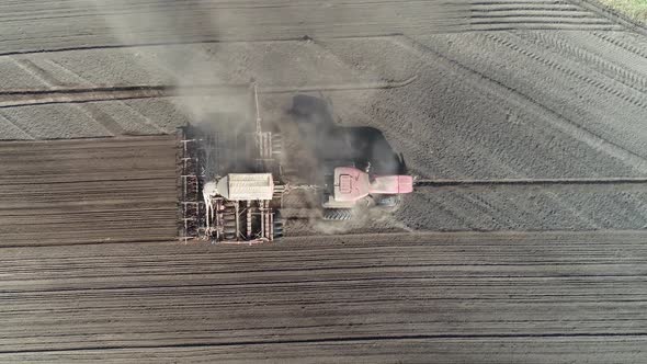Agriculture Farm Tractors Plow the Earth in Field Dust in the Field View From Height Grain Sowing