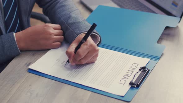 Close up confident manager signing agreement of the partnership.