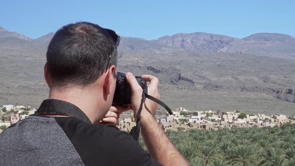 Caucasian Male Tourist Taking Photos of Abandoned Old Ruined Village of Al Hamra Near Nizwa, Oman