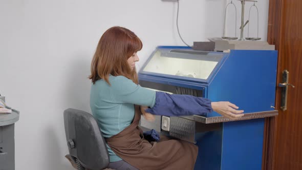 Female Artisan Puts On Arm Cover Sleeves For Protection At Pet Jewelry Workshop