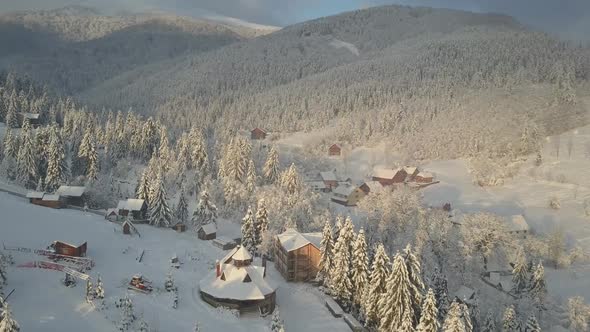 Aerial View of Snow-covered Houses in Mountains. Rural Landscape in Winter. Carpathian Village in