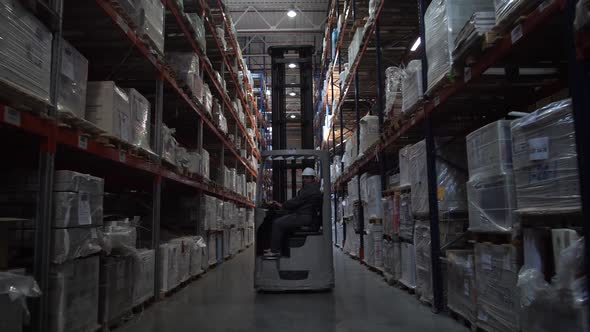 Forklift Moves Between Racks with Products