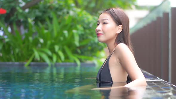 Young asian woman enjoy around outdoor swimming pool for leisure