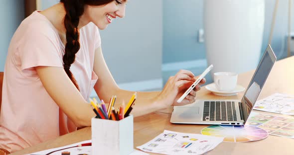 Beautiful executive sitting at desk and using digital tablet