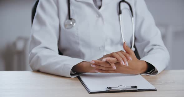 Closeup of Human Female Body Sitting at Table in Clinic Hospital, Moving Her Hands, Actively