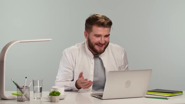 Young Man is Typing on the Computer Browsing the Web Looking at the Screen and Speaks Oh My God with