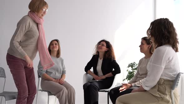 Mature Woman is Standing Up and Telling Her Story in a Psychotherapist's Office During Group Therapy