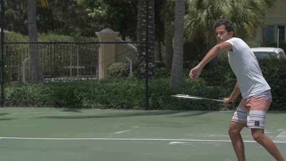 A young man playing tennis with his girlfriend.