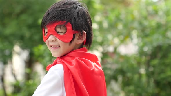 Asian Child In In Superhero Costume Playing In The Park