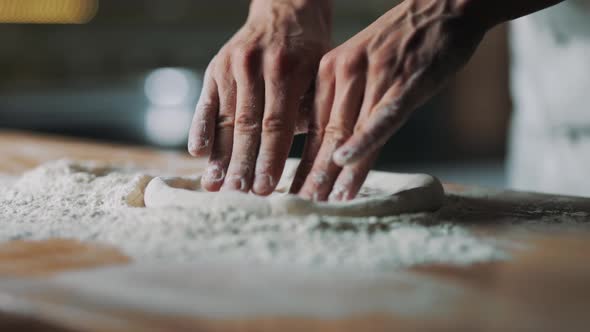 Close Up of Chef's Hands Forming Dough for Pizza Base