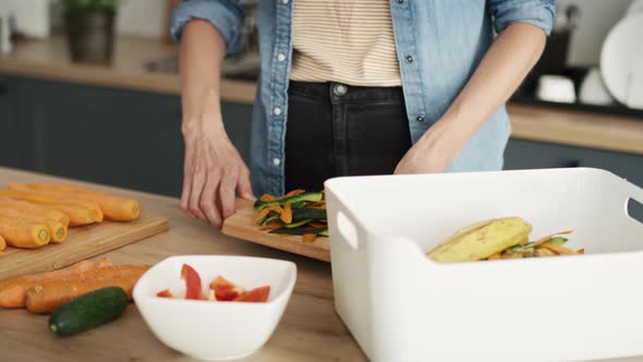 Static video of woman throwing organic waste in the kitchen. Shot with RED helium camera in 8K.