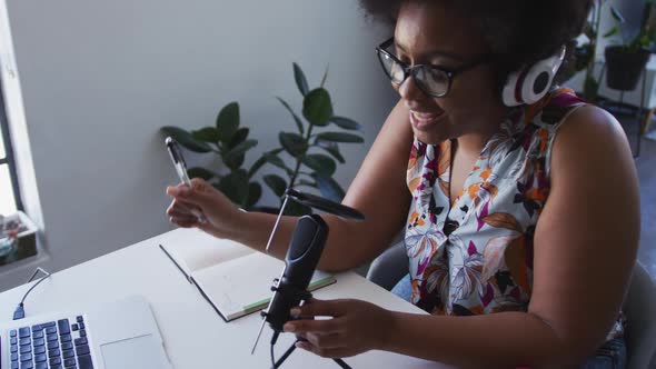 African american female plus size vlogger wearing headphones recording a video blog using microphone