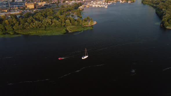 Aerial view of the modern sailboat sailing on the river