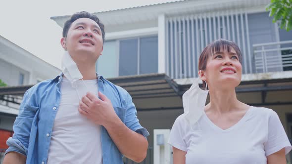 Asian couple feeling fresh and relax, enjoy freedom after quarantine in front of their house.