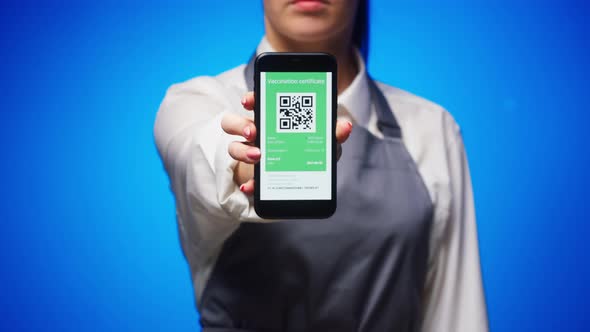 Woman Worker Showing on Phone Vaccination Passport with Qr Code on Blue Background International