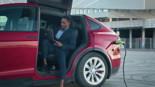 African American Businessman in Stylish Suit Using Modern Laptop for Remote Work