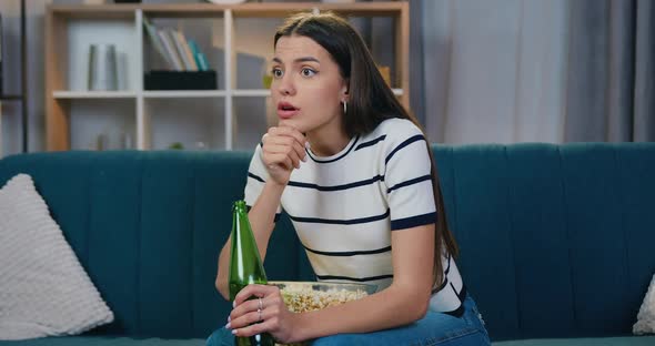 Woman Sitting on the Couch in front of TV During Watching Sports Competition