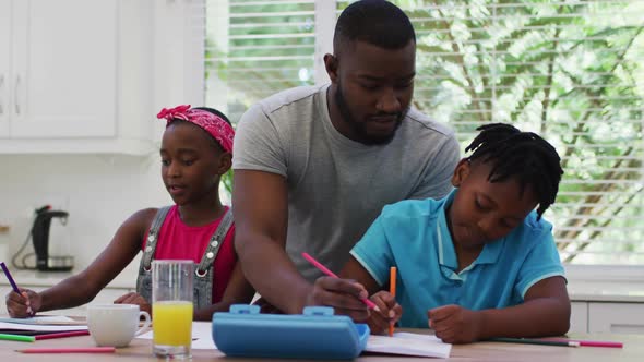 African american father and helping his son with homework at home