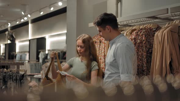 Man and Woman Walking Indoor of Fashion Clothes Store