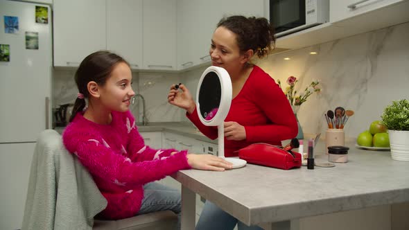 Happy Preteen Girl Looking at Vanity Mirror Checking Makeup Indoors