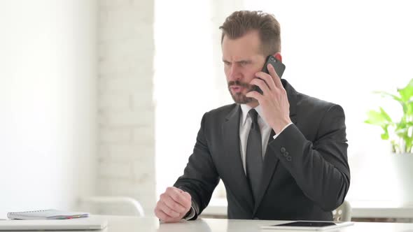 Angry Young Businessman Talking on Phone