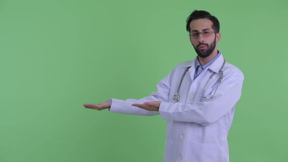 Stressed Young Bearded Persian Man Doctor Showing Something