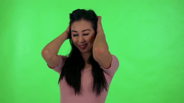 Young Attractive Asian Woman Rejoices and Looks To Camera - Green Screen Studio