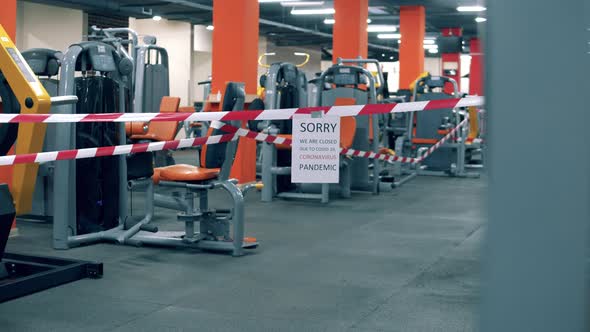 Empty Fitness Center with a Warning Tape and a Closing Notice