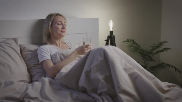 Attractive Woman Drinks Water Before Going to Bed