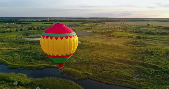 Travel in the air at sunset. Hot air balloon flying in the countryside. Colorful aerostat over the f