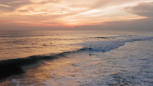 Aerial View of Surfer Riding Sunset Ocean Wave