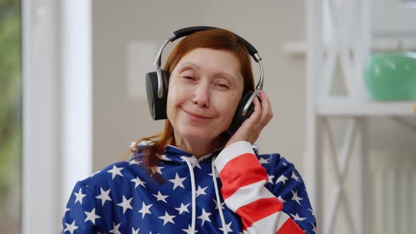 Portrait of Confident Retiree in Headphones Listening to Music Looking at Camera Smiling