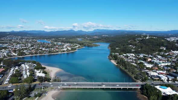 High scenic panorama of Tallebudgera Creek bridge with the Gold Coast hinterland in the foreground.