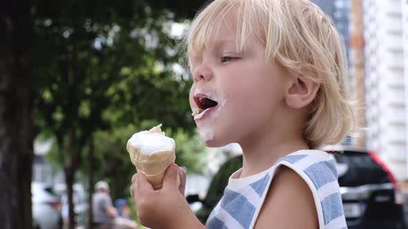 a Small Child Eats White Ice Cream with Great Pleasure