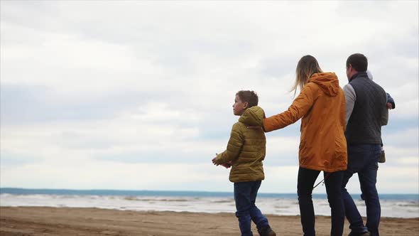 Happy Family Walking Along the Shore