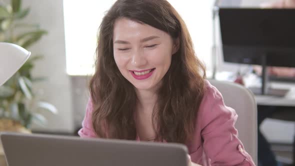Young Beautiful Brunette Works on a Laptop Computer in Cool Creative Agency in a Loft Office