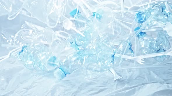 Super Slow Motion Shot of Plastic Trash Falling on Blue Gradient Background at 1000Fps