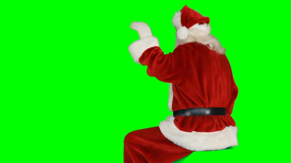 Rear view of santa claus waving hand