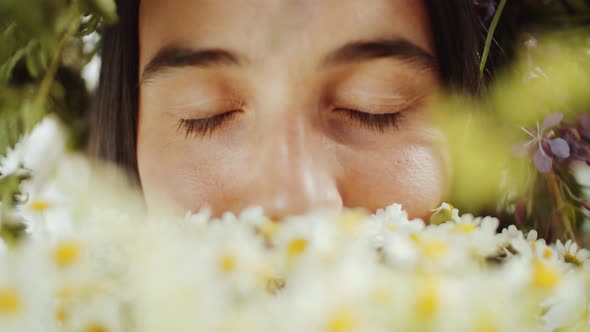 Close Up of Young Woman Smelling Chamomile Flowers