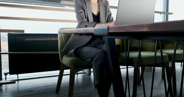 Concerned Woman Working on Laptop Computer and Looking Away Thinking Solving Problem at Office