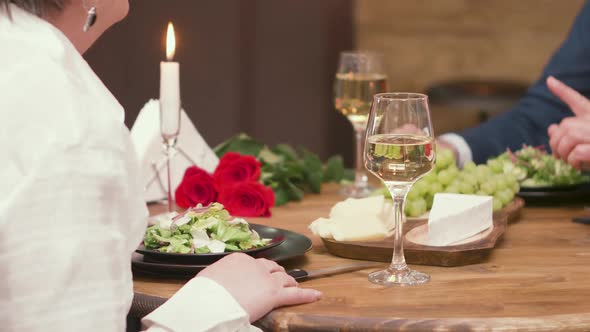 Close-up of Mature Male and Female Hands Having Wine and Food