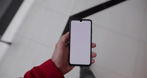 Male Hand Using Empty Screen of Smartphone Walking in the Mall